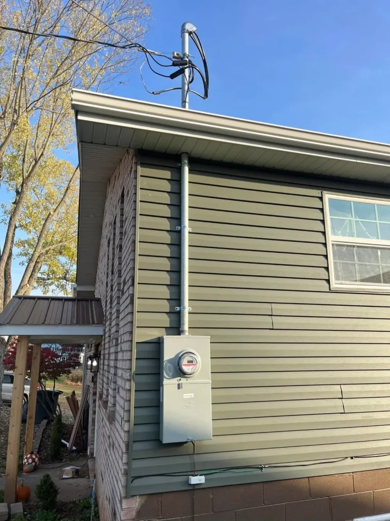 A house featuring a utility meter on the wall and a window, showcasing a typical residential exterior.